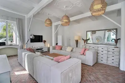 a living room with two white couches and a tv at Château vert in Cavaillon