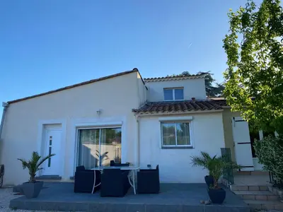 a white house with a table in front of it at Un jour en Provence in Cabannes