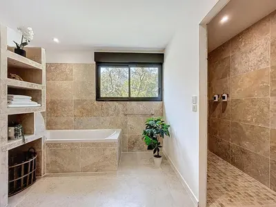 a bathroom with a tub and a window at Chambre Deluxe - vue jardin - située dans le triangle d'or du Luberon in Ménerbes