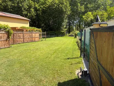 a backyard with a fence and a grass yard at Au doux paillis Sorgue in Le Thor