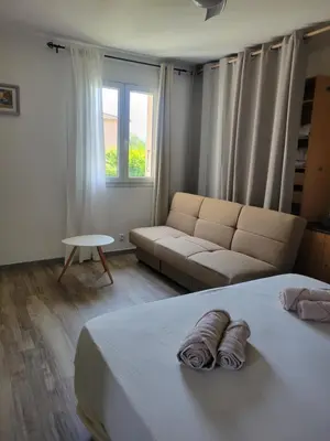 a bedroom with a bed and a couch and a window at Mamimonik in Lauris