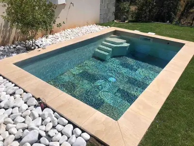 a swimming pool with rocks in a backyard at Quiet house in provence in Lauris