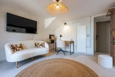a living room with a white couch and a tv at La Note Bleue Luberon in Maubec