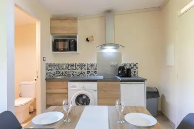 a kitchen with a table and two wine glasses at Le Romarin - Hypercentre Studio - Clim - WiFi in Apt