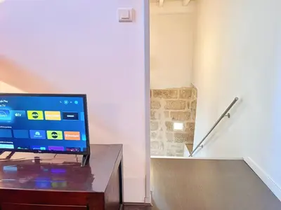 a flat screen tv sitting on top of a wooden table at Miraluna - Village médiéval, calme, insolite, 6 personnes in Miramas