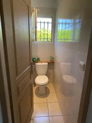 a bathroom with a toilet and a window at Maison de vacances in Le Thor
