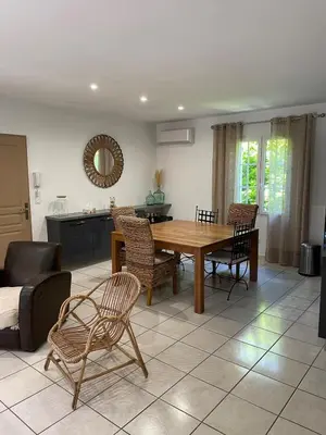 a living room with a wooden table and chairs at Maison de vacances in Le Thor