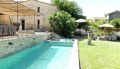 a swimming pool in the yard of a house at La Grande Bergerie in Saint-Saturnin-les-Apt