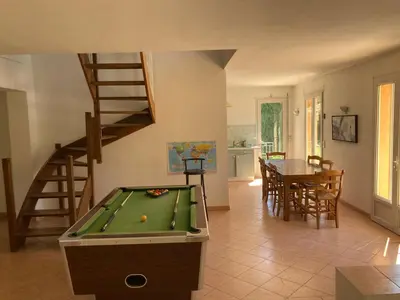a living room with a pool table and a staircase at Grande maison avec piscine in Aix-en-Provence