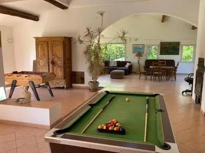 a large living room with a pool table at Grande maison avec piscine in Aix-en-Provence