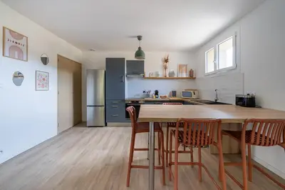 a kitchen with a wooden table and chairs at Maison proche Avignon Clim Terrasse wifi 4pers in Jonquerettes