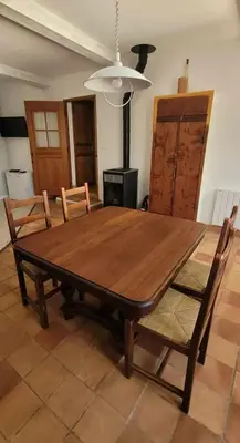 a wooden table and chairs in a living room at Maison conviviale avec jardin à Revest-des-Brousses in Vachères