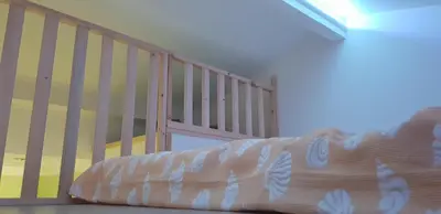 a bed with a crib in a room at Mayka in LʼIsle-sur-la-Sorgue