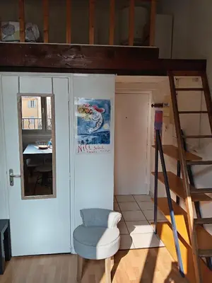 a living room with a ladder and a chair at Charmant studio centre historique Aix in Aix-en-Provence