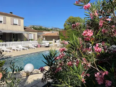 a house with a swimming pool with pink flowers at Villa de caractères,piscine, vue sur le luberon,3 chambres in Cheval-Blanc