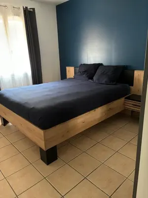 a bed with a wooden frame in a room at Villa de caractères,piscine, vue sur le luberon,3 chambres in Cheval-Blanc