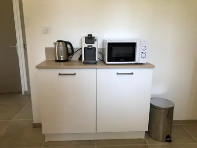 a microwave sitting on top of a white cabinet at Gîte 6 pers en Provence avec grande piscine partagée avec 2nd gîte - 6 pers house in Provence with a large swimming pool to be shared with a 2nd house in Cornillon-Confoux