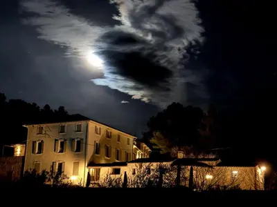 a full moon shines behind a building at night at Exceptional Bastide in Lourmarin, Luberon in Lourmarin