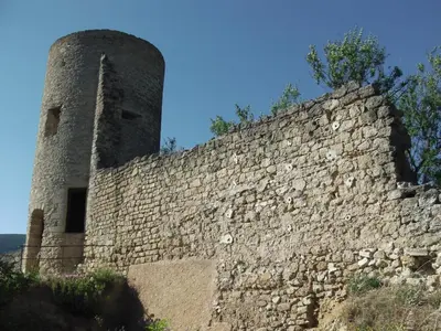 a stone wall with a tower on top of it at Les Chambres De Charlotte in Cucuron