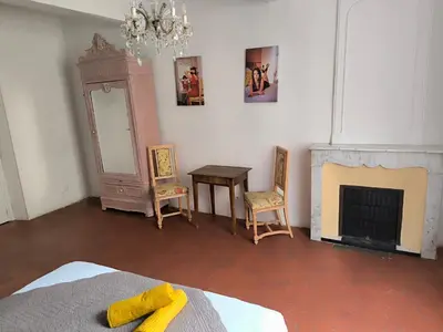 a bedroom with a fireplace and a bed and a mirror at Les Chambres De Charlotte in Cucuron