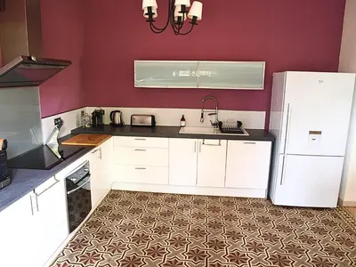 a kitchen with white cabinets and a white refrigerator at Mas Bruneau in Noves
