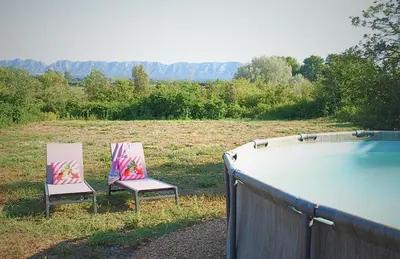 two chairs sitting next to a swimming pool at Mas Bruneau in Noves