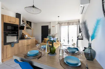 a dining room with a table and blue chairs at Dolce Vita Piscine in LʼIsle-sur-la-Sorgue