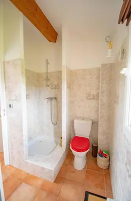 a bathroom with a toilet with a red seat at Magnifique villa avec piscine à 2 pas du centre d'Aix in Aix-en-Provence