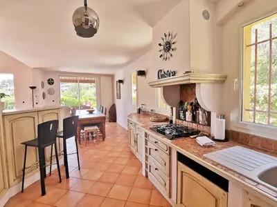 a kitchen with a counter and a table with chairs at Magnifique villa avec piscine à 2 pas du centre d'Aix in Aix-en-Provence
