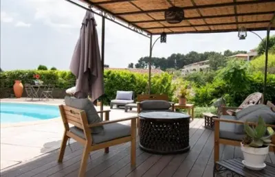 a patio with chairs and an umbrella and a pool at Magnifique villa avec piscine à 2 pas du centre d'Aix in Aix-en-Provence