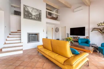 a living room with a yellow couch and a tv at Magnifique villa avec piscine à 2 pas du centre d'Aix in Aix-en-Provence
