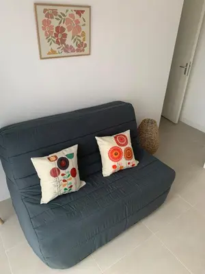 a blue couch with two pillows in a living room at Villa Serena - 3 chambres grand confort - 6 personnes in Carpentras