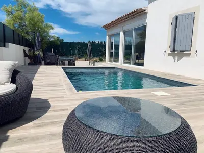 a swimming pool with a table and a house at Maison agréable pour vacances réussies in Vernègues