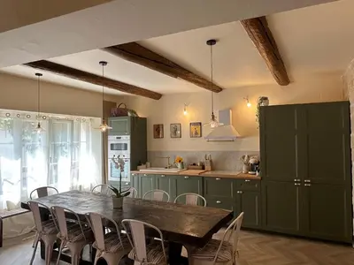 a kitchen with a table and chairs in a room at Les Romarins - 5 chambres in Lauris