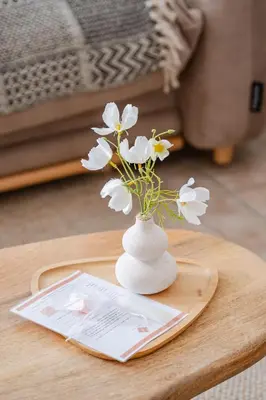 a vase with white flowers on a table at La Cour Secrète - Suite Bali Balnéo privé Carpentras in Carpentras