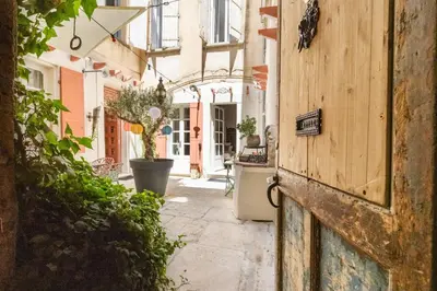 an alley with potted plants and a building at La Cour Secrète - Suite Bali Balnéo privé Carpentras in Carpentras