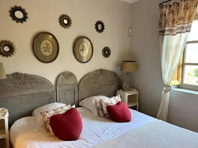 a bedroom with two red pillows on a bed at Mas aux gourmandises in Oppède
