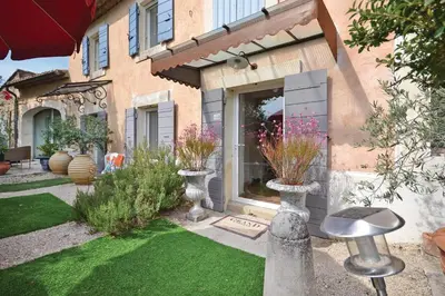 a house with a garden with vases on the lawn at Mas Bosca Brun in Cheval-Blanc