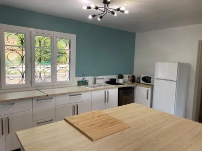 a kitchen with a table and a white refrigerator at Maison Aix-en-Provence in Aix-en-Provence