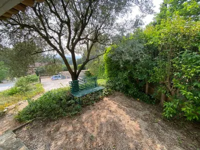 a green park bench sitting next to a tree at Maison Aix-en-Provence in Aix-en-Provence