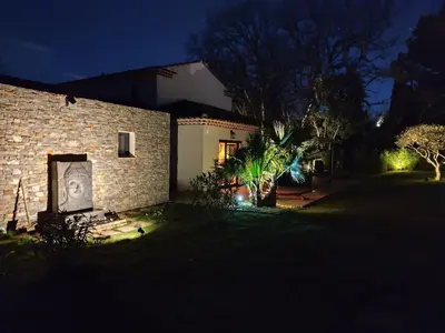 a brick house with a picture of a woman on the side at Chamarte villa piscine chauffées jardin clôturé Aix en Provence in Aix-en-Provence