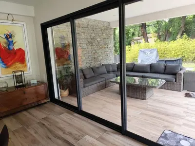 a living room with sliding glass doors at Chamarte villa piscine chauffées jardin clôturé Aix en Provence in Aix-en-Provence