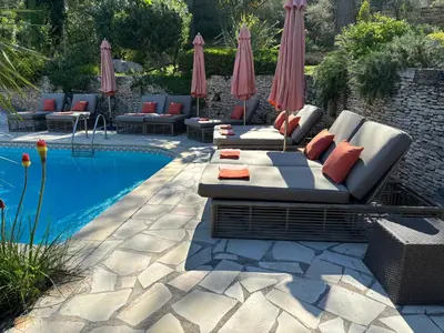 a patio with lounge chairs and a swimming pool at La Pasclapierre in Orgon