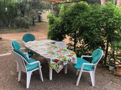 a table and chairs with a floral table cloth on it at Villa Le Pin in Rognes