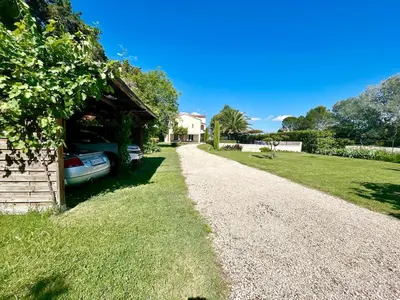 a house with a car parked next to a gravel driveway at Villa 7 chambres, piscine et jardins privés, pas de voisins in Le Thor