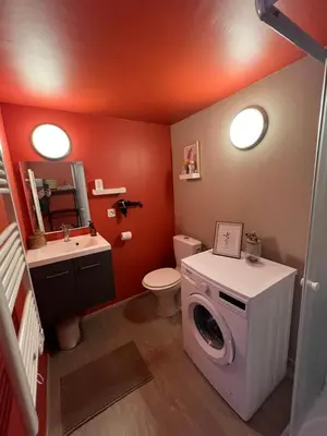 a bathroom with a washing machine and a washer at appartement avec piscine in Gargas