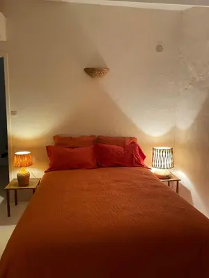 a bedroom with a bed with red pillows and two lamps at Provencal Villa With Panoramic Views In Luberon in Apt