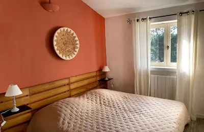 a bedroom with orange walls and a bed and a window at Mas provençal - Beautiful Provencal farmhouse, heated pool in Murs