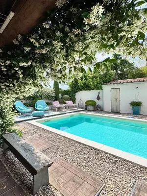 a swimming pool in a yard with a table and chairs at La roulotte de Valou in Noves