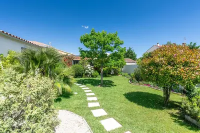 a garden with a path in the grass with trees at La roulotte de Valou in Noves